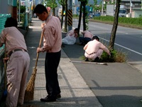 会社周辺を清掃する社員の写真